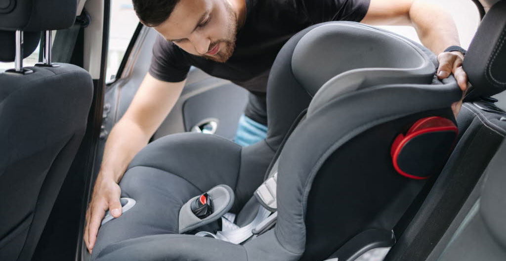 Break familial moderne avec coffre ouvert, parent chargeant des bagages pour week-end, siège enfant ISOFIX visible à l'intérieur, devant maison périurbaine française